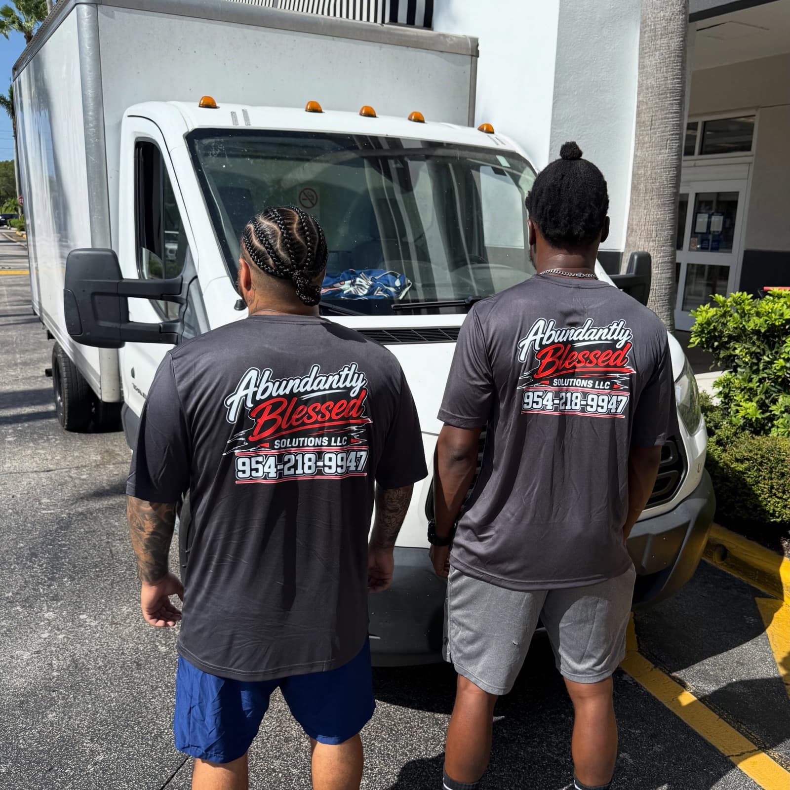The Abundantly Blessed Solutions crew in branded uniforms standing at their delivery truck in South Florida